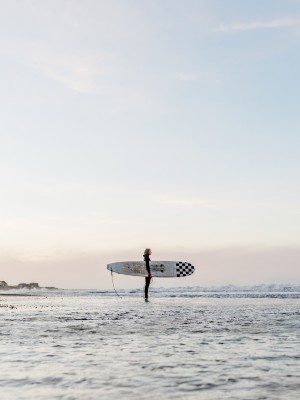 Surfer i vandkanten